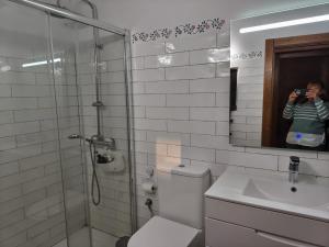 a woman taking a picture of a bathroom with a shower at Casa Fabiana in Montenegro de Cameros +47 photos