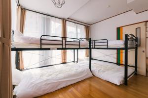 two bunk beds in a room with a window at Yasuragi Nakasu in Fukuoka