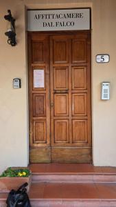a wooden door in a building with a sign on it at Affittacamere Dal Falco in Pienza
