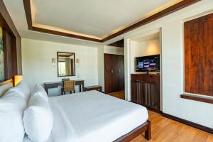 a bedroom with a white bed and a desk at City Inn Vientiane in Vientiane