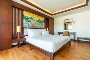 a bedroom with a bed and a painting on the wall at City Inn Vientiane in Vientiane