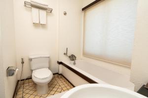 a bathroom with a toilet and a tub and a sink at City Inn Vientiane in Vientiane