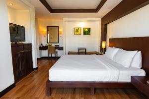 a bedroom with a large white bed and a desk at City Inn Vientiane in Vientiane +42 photos