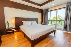 a bedroom with a large bed and a large window at City Inn Vientiane in Vientiane