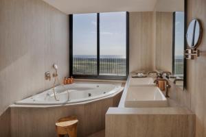 a bathroom with a tub and a large window at Gordonia Zikhron Ya'akov in Zikhron Ya'akov +22 photos