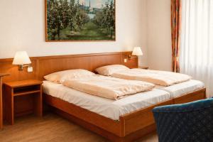 a bedroom with two beds and a painting on the wall at Diekstuv Hotel in Jork
