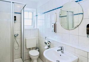 a bathroom with a toilet and a sink and a mirror at Diekstuv Hotel in Jork