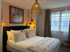 a bedroom with a large bed and a chandelier at Hôtel Le Neptune en Camargue in Saintes-Maries-de-la-Mer +96 photos