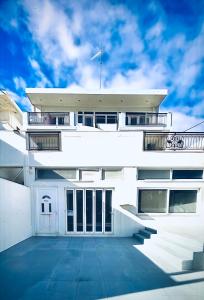 a white building with a blue sky in the background at Meltemi Evia in Paralía
