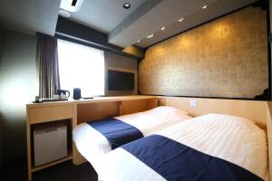 Hotel Wing International Select Asakusa Komagata في طوكيو: غرفة نوم فيها سرير وتلفزيون