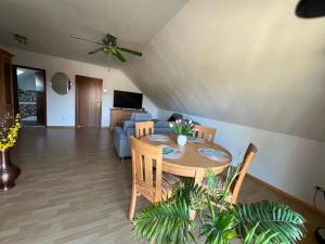 a living room with a table and a couch at Ferienwohnung Am Briesetal in Birkenwerder +6 photos