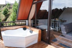 a bathroom with a white bath tub on a balcony at Glamping Triangle Kusumanagara 1 in Bandung