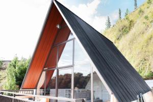 a house with a pointed roof with glass windows at Glamping Triangle Kusumanagara 1 in Bandung