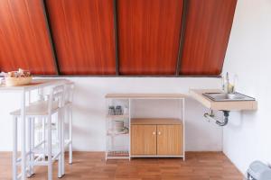 a kitchen with a sink and a table and a counter at Glamping Triangle Kusumanagara 1 in Bandung