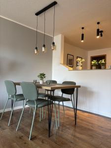 a dining room with a wooden table and chairs at 100qm Apartment mit Regendusche & Top-Lage in Mücheln
