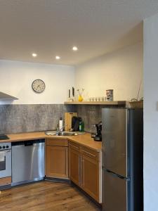 a kitchen with stainless steel appliances and a clock on the wall at 100qm Apartment mit Regendusche & Top-Lage in Mücheln +19 photos