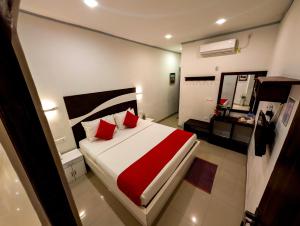 a bedroom with a large bed with red pillows at Diva Villa Airport Transit Hotel in Katunayaka