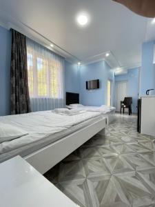 a bedroom with a large bed and a tv on the wall at Marina kvariati in Kvariati