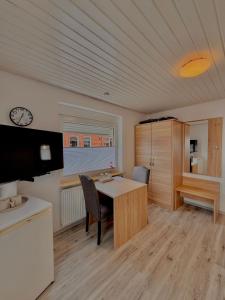 a kitchen with a table and chairs in a room at Pension Dang in Norddeich