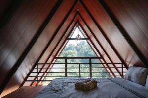 a bed in a room with a large window at Glamping Triangle Kusumanagara 1 in Bandung