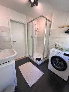 a bathroom with a washing machine and a washer at Anna's Waldchalet - FeWo Waldblick in Hannoversch Münden