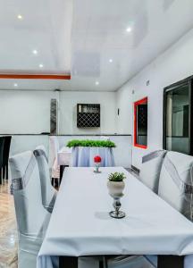 a dining room with a white table and chairs at Malbon Green Executive Plus Lodge in Kafue