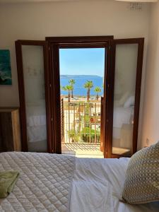 a bedroom with a bed and a view of the ocean at Fort Chambray Island Views in Għajnsielem +21 photos