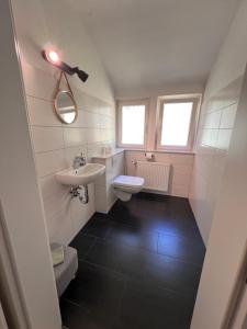 a bathroom with a sink and a toilet at Anna's Waldchalet - FeWo Waldblick in Hannoversch Münden +9 photos