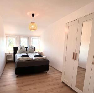 a bedroom with a bed and a pendant light at Anna's Waldchalet - FeWo Waldblick in Hannoversch Münden