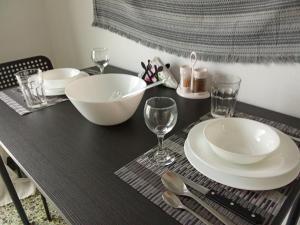 a table with plates and wine glasses on it at City Apartment Ierapetra 2A in Ierapetra +4 photos