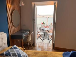 a bedroom with a desk and a table with a balcony at Ondablurooms1 in Pizzo +19 photos