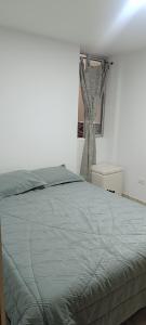 a bedroom with a bed with a gray comforter at Habitación in Itagüí