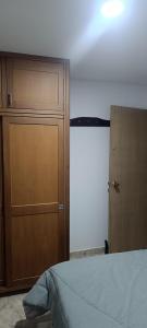 a bedroom with a bed and a wooden door at Habitación in Itagüí