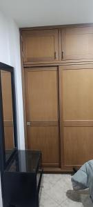 a closet with wooden doors and a glass table at Habitación in Itagüí