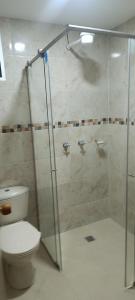 a bathroom with a toilet and a glass shower at Habitación in Itagüí