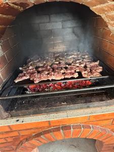 a bunch of meat cooking on a grill at Casa Ionel si Dani in Fundata