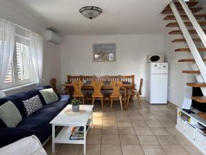a living room with a blue couch and a table at Bogi House in Balatonfüred