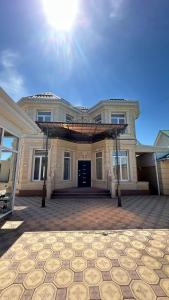 a large house with a large driveway in front of it at Гостевой дом in Tokmok