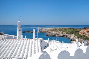 a white church with the ocean in the background at Apartment BINIBECA 60 in Binibeca