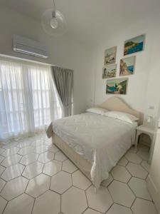 a bedroom with a bed and a white tiled floor at Casa Stinga in Capri