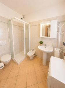 a bathroom with a shower and a toilet and a sink at Villa Dascia - Agenzia Cocal in Caorle
