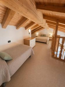a bedroom with a bed and a couch and wooden ceilings at Villa Dascia - Agenzia Cocal in Caorle