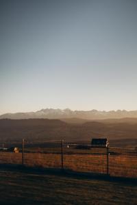 a fence in a field with mountains in the background at Gorczański Lux Chalet in Szlembark +103 photos