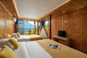 two beds in a room with a television and a balcony at happy live hotel in Heping