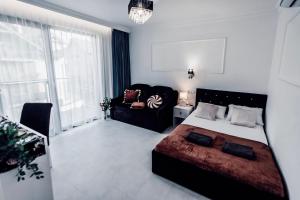 a bedroom with a bed and a couch at Willa Piryt - Kryształowe Wille Krynica Morska in Krynica Morska