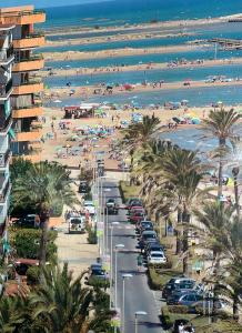 a view of a beach with palm trees and people at CASA DEL MAR-Costa Daurada in Cunit