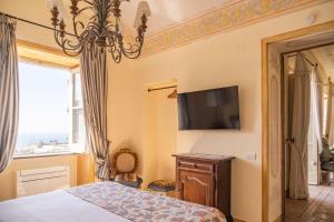 a bedroom with a bed and a tv on the wall at Palazzo Nobili in Capri +31 photos