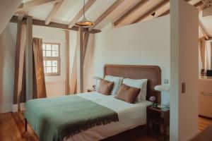 a bedroom with a large bed with a green blanket at Collares Sintra Petit Palais in Sintra +141 photos