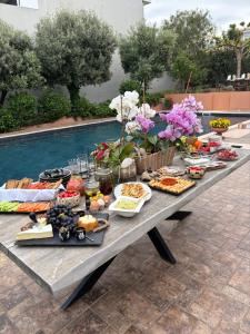 a picnic table with food on it next to a pool at Omma slow living villa in Rafina