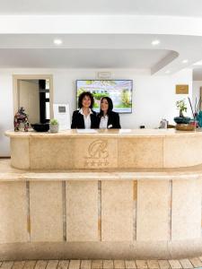 two women are standing at a reception desk at Borgo di Riaci Beach Resort in Santa Domenica +28 photos